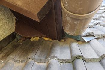 Dachanschluss an einem Fallrohr mit sichtbaren Zwischenräumen.