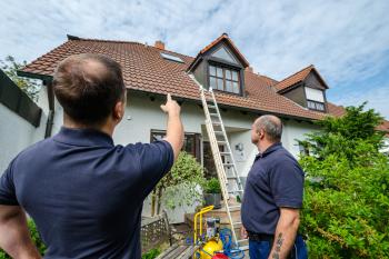Kontrolle des Dachbereichs an einem Wohnhaus.