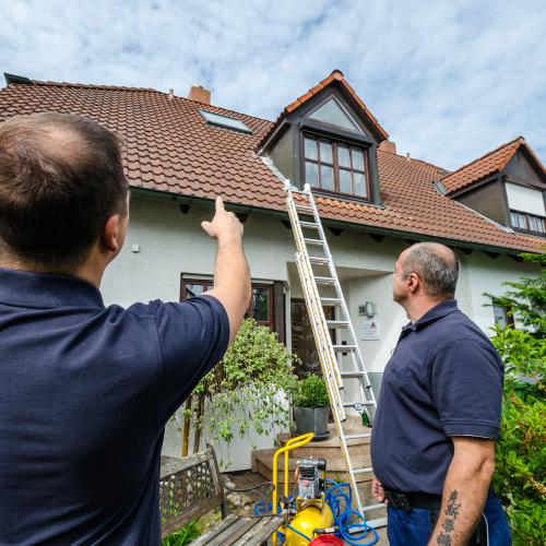 Kontrolle des Dachbereichs an einem Wohnhaus.